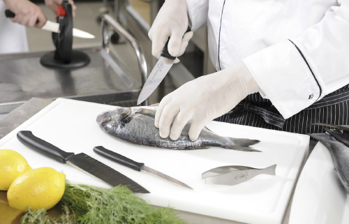 CHEF IN KITCHEN CUTTING FISH