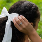 Sterling Silver Dimensional Bow Ring on model hand touching bow in hair