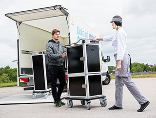 Two workers moving a ScanBox unit from a transport vehicle