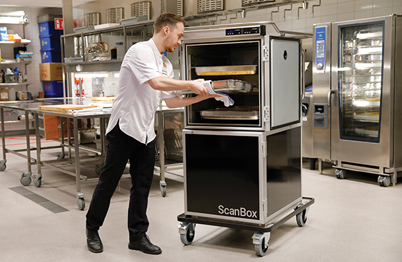 Male chef loading a food tray into a ScanBox unit