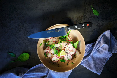 F.DICK Superior series chef knife laying across a plate of freshly prepared food